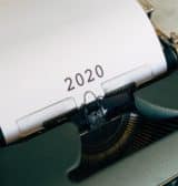 A typewriter with a piece of paper with 2020 typed on it